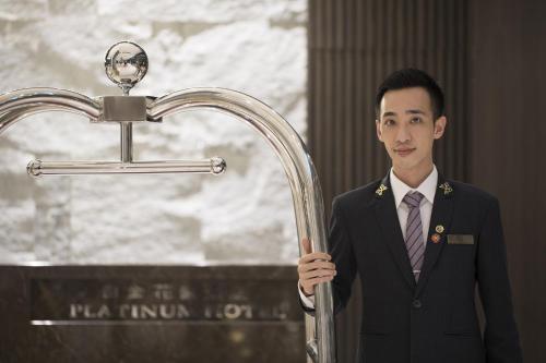 a man in a suit standing next to a faucet at Platinum Hotel in Xindian