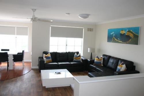 a living room with a black couch and a table at Seaspray Beach Holiday Park in Dongara