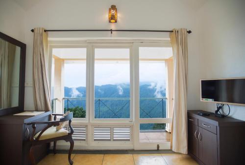 a living room with a large window with a view at After the Rains - Rainforest Lodge in Meppādi