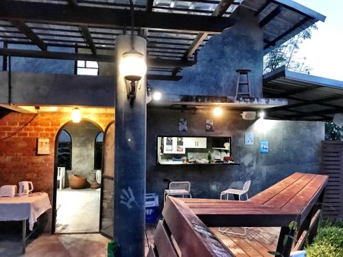 a patio with a wooden table and a dining area at Hip Home at Hod in Hot