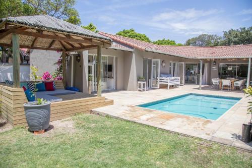 a backyard with a swimming pool and a house at Lemon Tree House in Plettenberg Bay