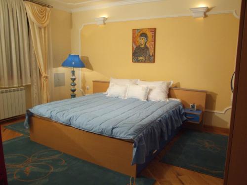 Schlafzimmer mit einem Bett mit Wandgemälde in der Unterkunft Hotel Tehnograd in Kraljevo
