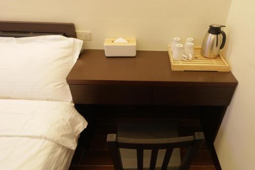 a bedroom with a desk with a bed and a night stand at Flower Homestay in Chishang