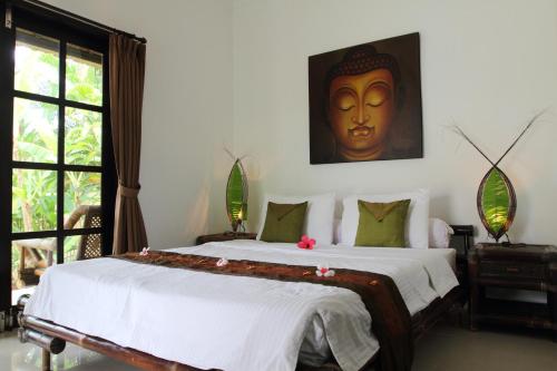1 dormitorio con 1 cama grande con máscara en la pared en Villa Bunga Melati, en Banjar
