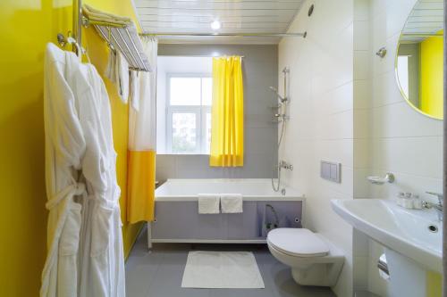 a bathroom with a tub and a toilet and a sink at Hotel Arbat in Yekaterinburg