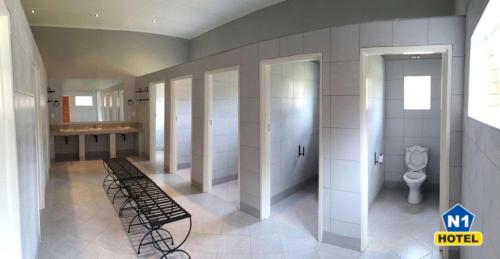 a bathroom with a toilet and a bench in it at N1 Hotel & Campsite Victoria Falls in Victoria Falls