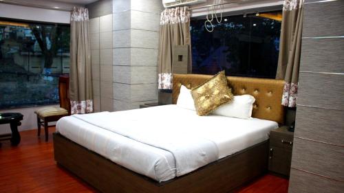 a bedroom with a bed and a large window at Hotel Shreemoyee Inn - Kamakhya Temple in Guwahati