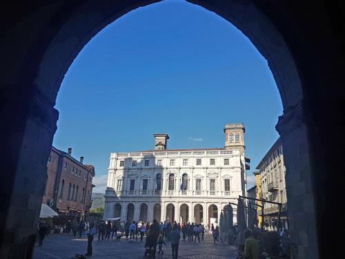 a large white building with people walking in front of it at Donizetti Royal in Bergamo