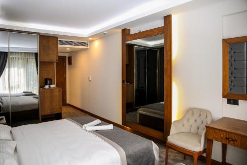 a bedroom with a bed and a chair and a mirror at New Gate Hotel in Ankara