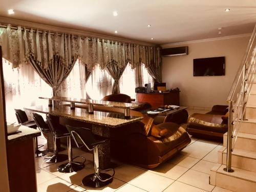 a living room with a couch and a table with a piano at Jay and Bee Guesthouse in Durban