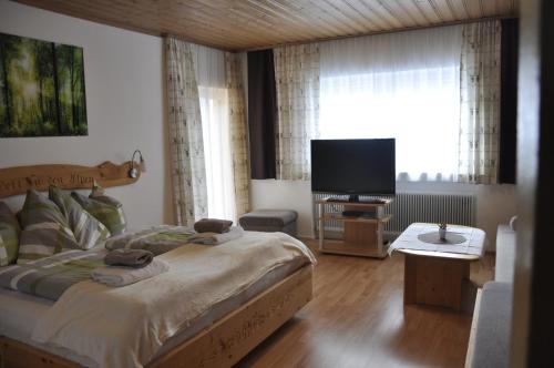 a bedroom with a bed and a flat screen tv at Haus Voithofer in Sankt Johann im Pongau