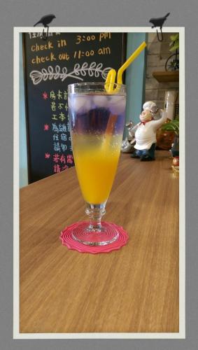 a drink sitting on top of a wooden table at Alien B&B in Hualien City