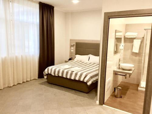 una camera con letto, lavandino e specchio di Academy Hotel a Fiumicino