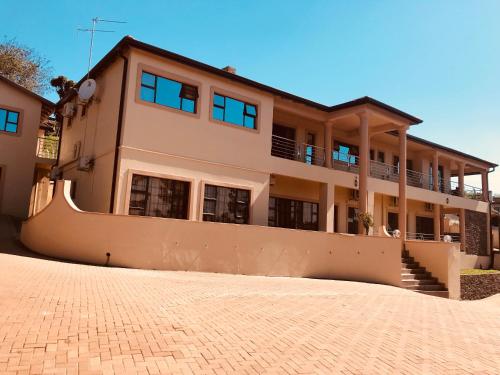 a house with a brick driveway in front of it at Jay and Bee Guesthouse in Durban