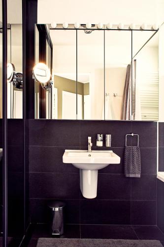 a bathroom with a sink and a large mirror at Forest Park by Zoom Apartments in Bratislava