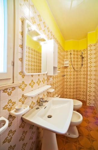 a bathroom with two toilets and a sink and a mirror at Olimpia in Bibione