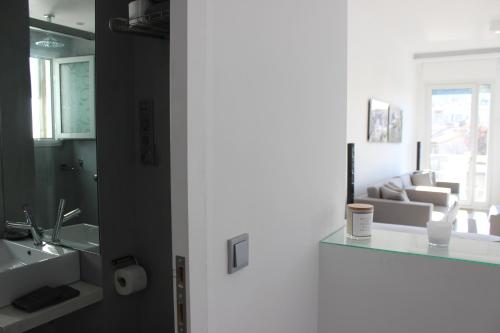 a bathroom with a sink and a living room at Best Views of Athens in Athens