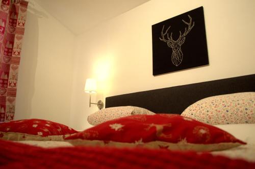 a bedroom with a bed with red pillows and a deer picture at Haus Susanne in Radstadt