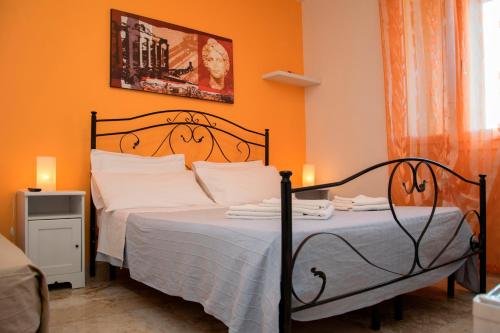 Un dormitorio con una cama con una pared naranja. en B&B DonnaLina, en Vignacastrisi