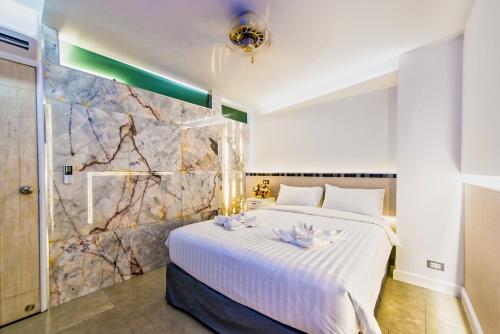 a bedroom with a large white bed and a stone wall at Viengping Mansion Chiang Mai - Heart of Nimman, Shopping & Cafes in Chiang Mai