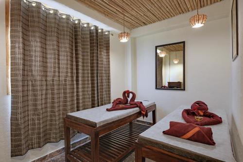 a room with two red towels on a bed and a mirror at The Baagh Ananta Elite Ranthambore in Sawāi Mādhopur