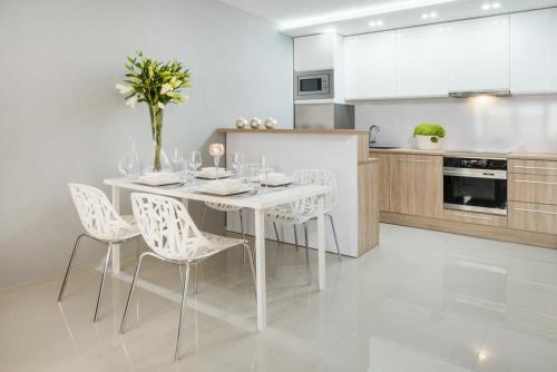 ヴロツワフにあるIcon Apartments Centrum 55m2の白いキッチン(白いテーブルと椅子付)