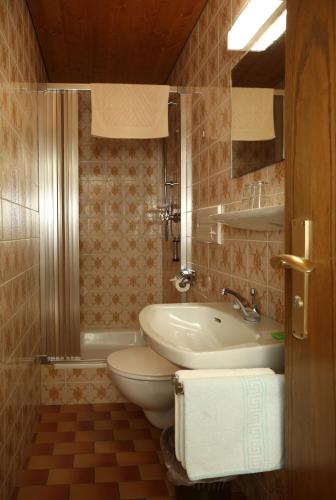 a bathroom with a sink and a toilet and a tub at Bio & Vegi Pension Krennleiten in Schönau am Königssee