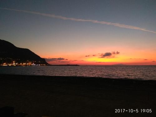 zachód słońca na plaży z oceanem w obiekcie Little Anema & Core w mieście Castellammare di Stabia