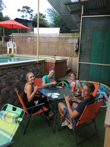 a group of people sitting at a table near a pool at Bella Vista Ranch Ecolodge in Turrialba