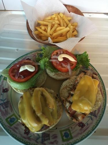 a plate of food with hamburgers and french fries at Bella Vista Ranch Ecolodge in Turrialba