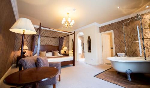 a bathroom with a tub and a bedroom with a bed at Ringwood Hall Hotel & Spa in Chesterfield