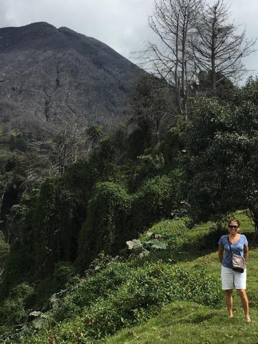 a woman standing on a hill looking at a mountain at Bella Vista Ranch Ecolodge in Turrialba