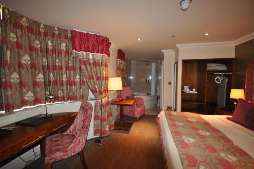 a hotel room with a bed and a desk and a bedroom at Ringwood Hall Hotel & Spa in Chesterfield