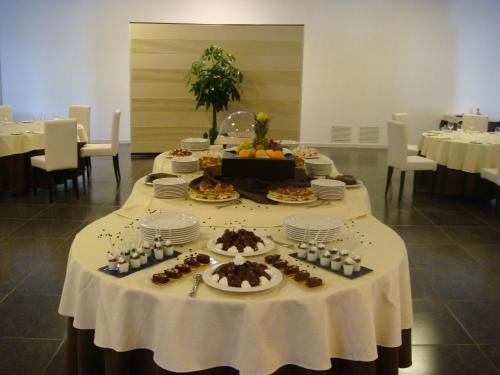 a table with plates of food and desserts on it at Santa Loja Hotel Residence in Tito