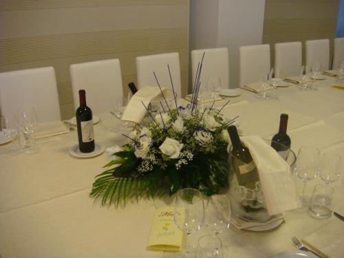 a table with a centerpiece of flowers and wine bottles at Santa Loja Hotel Residence in Tito
