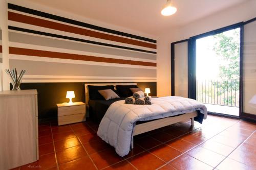 ランダッツォにあるla casa della querciaのベッドルーム1室(ストライプの壁のベッド1台付)