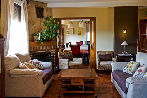 a living room with two couches and a table at Casa Rural Alquería de Segovia in Tizneros