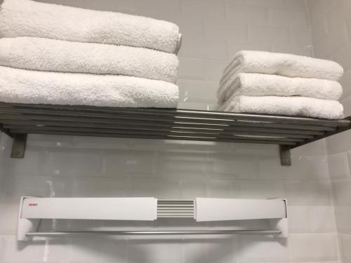 three towels are on a shelf in a bathroom at Appartement Seine et Marais in Paris