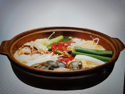 a bowl of soup with vegetables and noodles at Jeju Feel House in Jeju