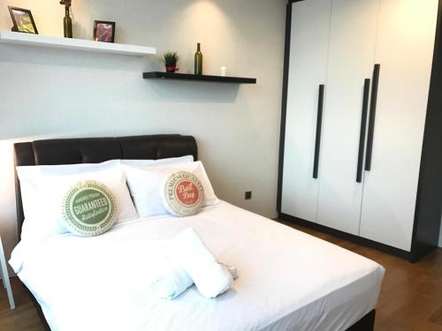 1 dormitorio con cama blanca y almohadas blancas en VORTEX SUITES KLCC by PNUT With NETFLIX, en Kuala Lumpur