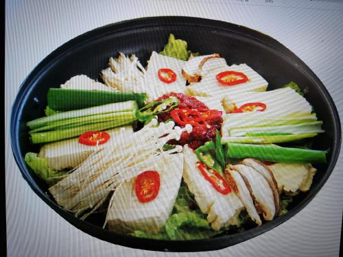 a pan filled with food with vegetables and meat at Jeju Feel House in Jeju