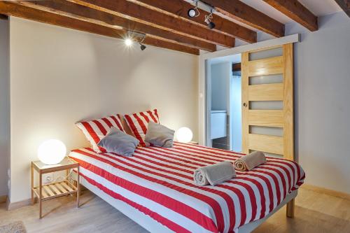 um quarto com uma cama grande com riscas vermelhas e brancas em Le Saint Pierre, atypique au coeur du centre ville em Caen