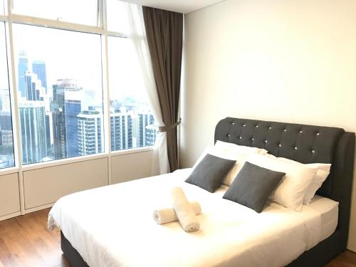 a bedroom with a bed with a large window at VORTEX SUITES KLCC by PNUT With NETFLIX in Kuala Lumpur