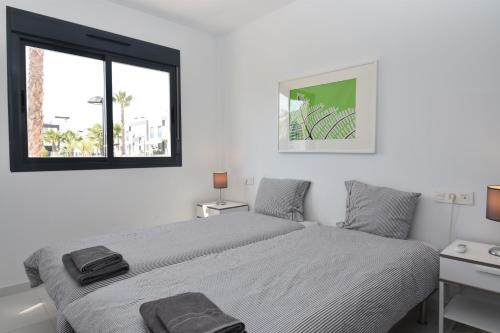 A bed or beds in a room at Oasis Beach VI South facing pool view La Zenia
