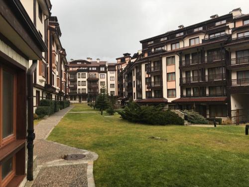 a row of apartment buildings with a green yard at Apartment in Downtown Complex Bansko in Bansko