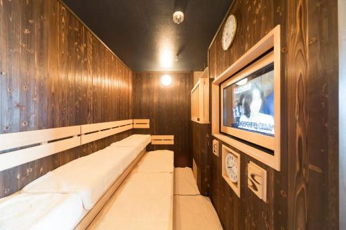 a room with wooden walls and a flat screen tv at Dormy Inn Kochi in Kochi