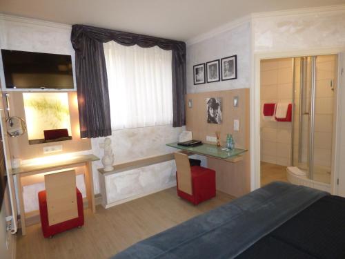 a bedroom with a bed and a desk and a window at Landhaus "Am Sonnenberg" in Diekholzen