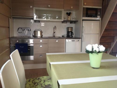 a kitchen with a table with a vase of flowers on it at Pyhäjärven Lomakylä in Ruolahti