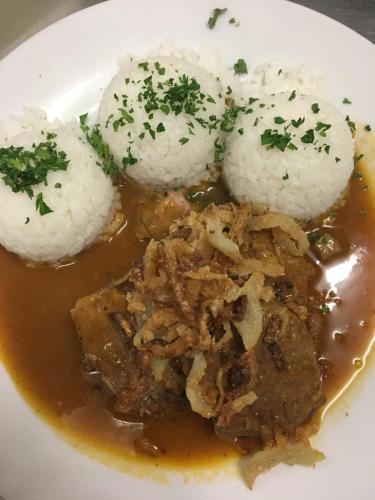 a plate of food with rice and meat and gravy at Penzion Na Solné stezce in Kašperské Hory