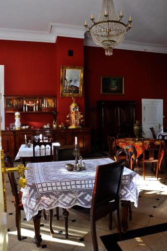 a dining room with red walls and a table and chairs at Apartamenty Carskie in Białowieża